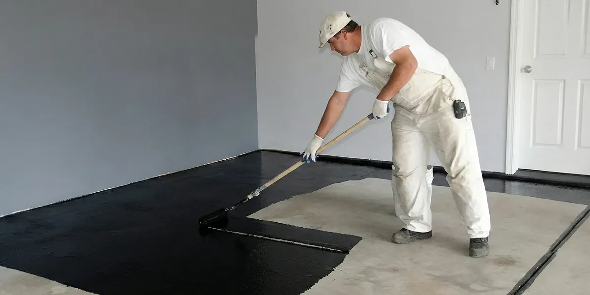 basement waterproofing professional applying waterproof coating to protect a basement floor in Buffalo, NY