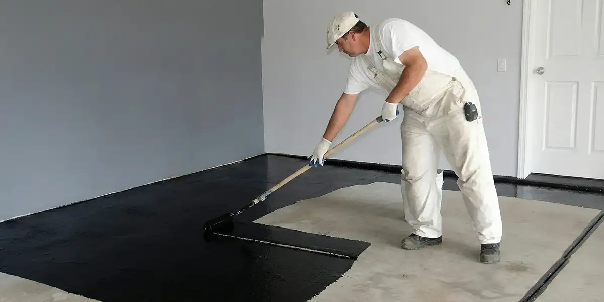 basement waterproofing professional applying waterproof coating to protect a basement floor in Buffalo, NY